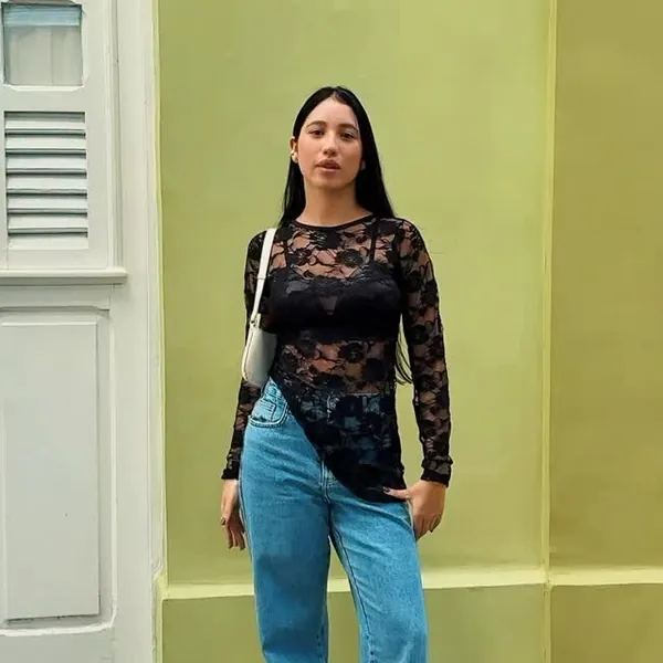 Cliente com blusa preta de renda e calça jeans clara