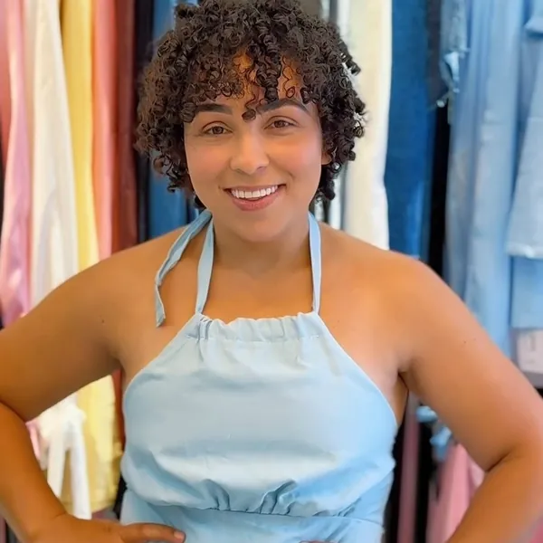Cliente com vestido azul claro frente única dentro da Loja Mariana